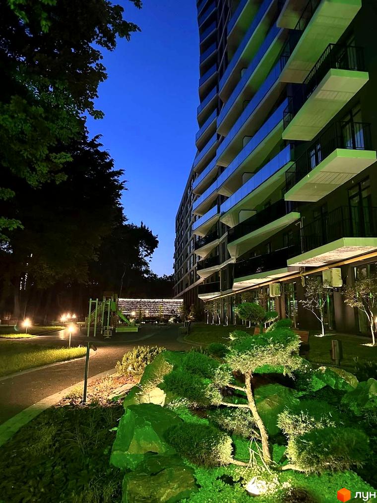 Житловий комплекс Tiffany: багатоповерхова будівля з балконами, освітлений двір з дитячим майданчиком та зеленими насадженнями.