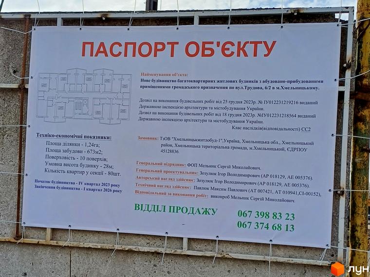 Інформаційний щит про будівництво багатоквартирних будинків по вулиці Трудова, 6/2 у Хмельницькому. На плакаті технічні характеристики та контакти відділу продажу.