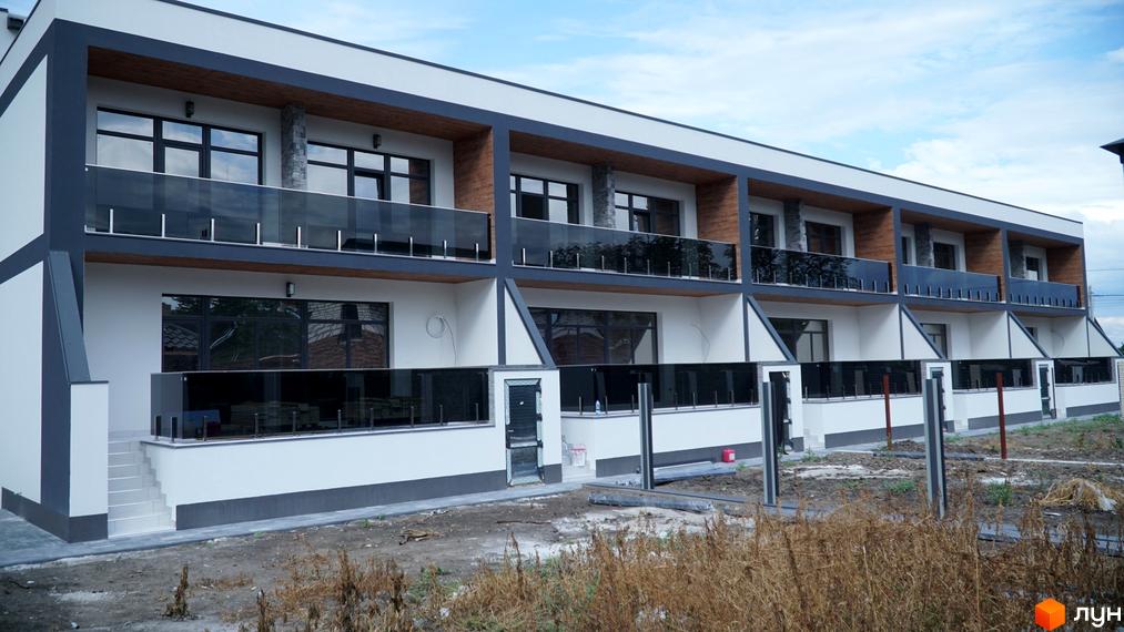 Зображення фасаду Житлового комплексу по вулиці Куроп'ятникова, 56. На фото будинок з балконами та прибудинкова територія.