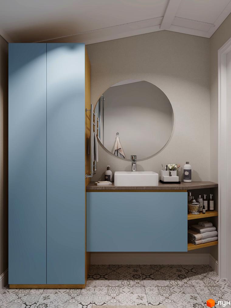 Інтер'єр ванної кімнати з блакитними шафами та круглим дзеркалом. На підлозі плитка з візерунком.