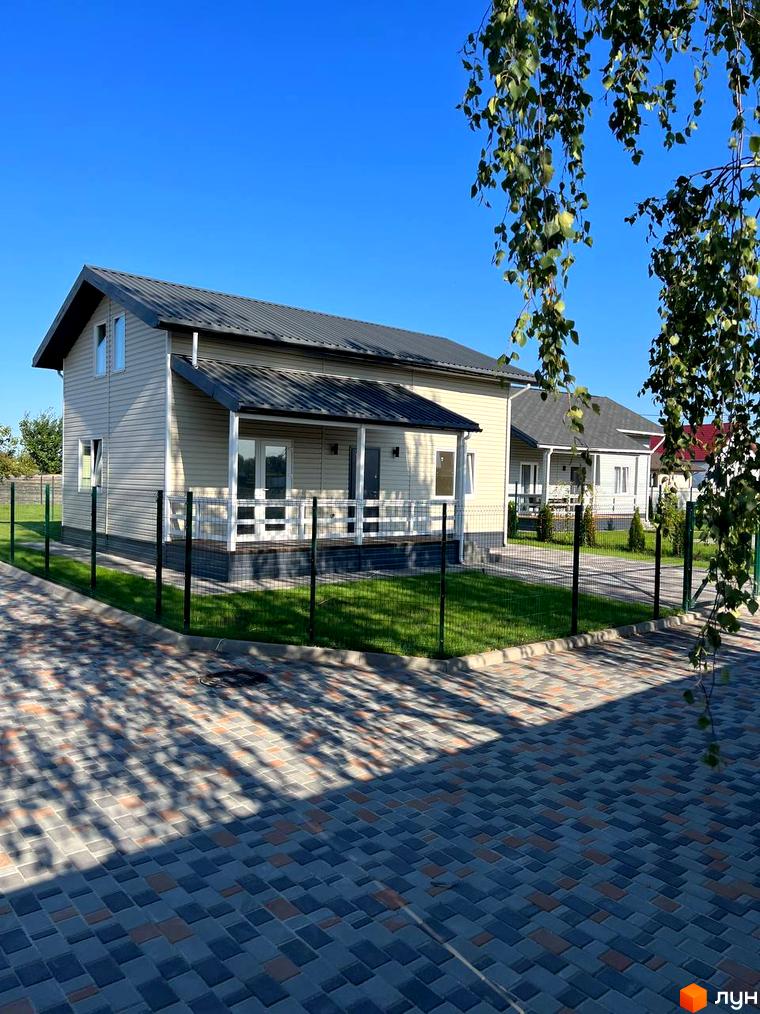 Зображення будинку в Котеджному містечку Lagom Village з прибудинковою територією та зеленим газоном.