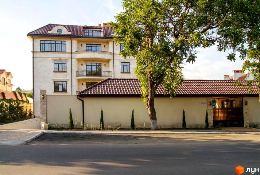 Клубний будинок „Ліон“ – елегантна архітектура з балконами та великими вікнами. Прибудинкова територія з доглянутим ландшафтом та парканом.