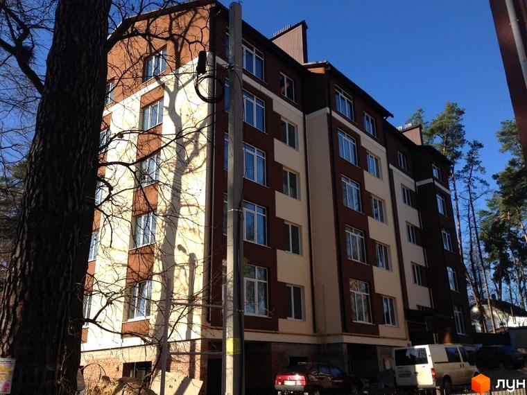 Зовнішній вигляд новобудови на вулиці Лермонтова, 6е. Будинок із коричневими та світлими фасадами, вікнами та деревами поруч.