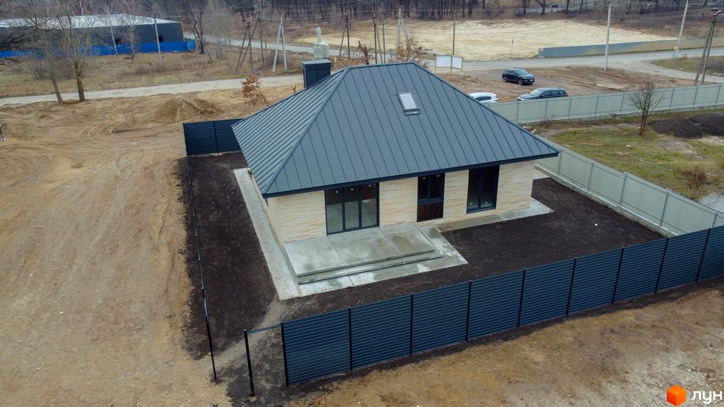 Котеджне містечко SMADE Park: одноповерховий будинок з сірим дахом та світлими стінами, огороджена територія з газоном та бетонною доріжкою.