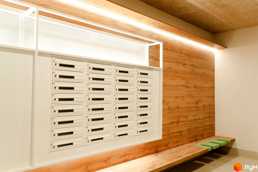 Комплекс Долішній: секція з поштовими скриньками та лавкою для відпочинку. Сучасний дизайн та функціональність для мешканців.