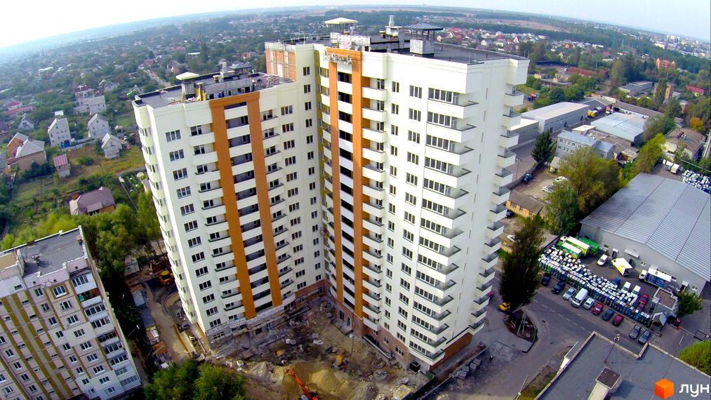 Житловий комплекс Південний – висотні будинки з біло-помаранчевими фасадами та балконами. Навколо – міська забудова та зелені насадження.