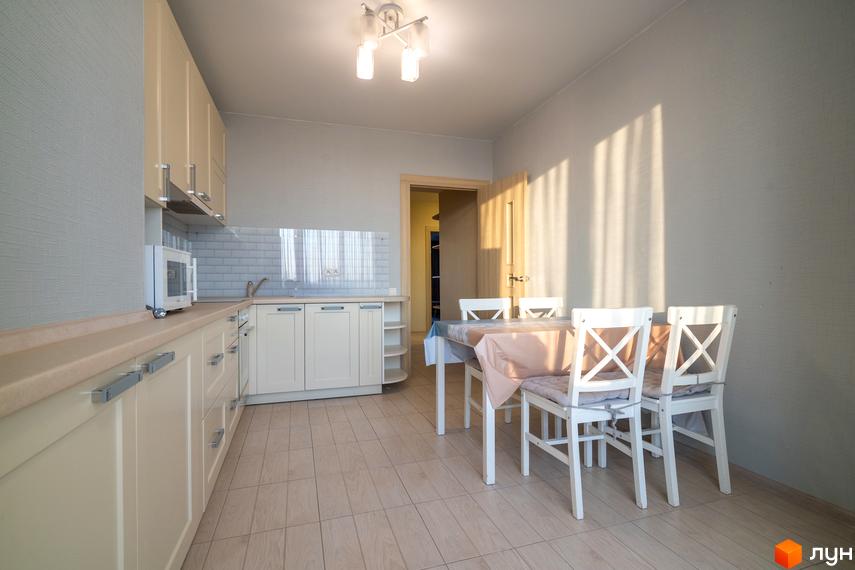 Фото кухні в Житловому комплексі Софіївський квартал. Інтер'єр кухні з білими меблями та обіднім столом.