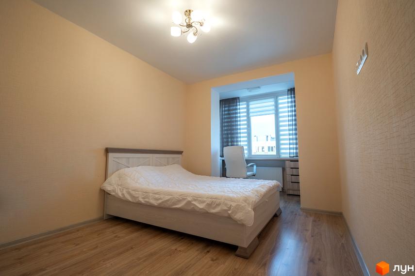 Фото кімнати в Житловому комплексі Софіївський квартал на вулиці Ак. Шалімова. На фото ліжко, вікно з жалюзі та штори, дерев'яна підлога.