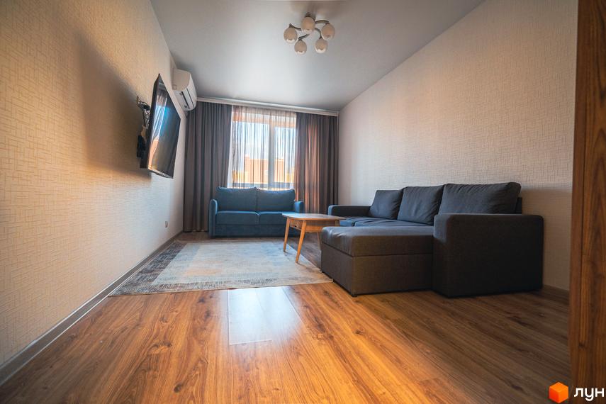 Інтер'єр квартири в Житловому комплексі Софіївський квартал по вул. Ак. Шалімова. Вітальня з диваном, телевізором та дерев'яною підлогою.