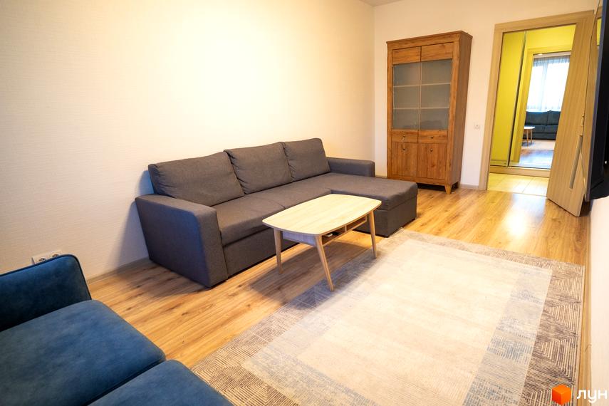 Інтер'єр квартири в Житловому районі Софіївський квартал на вулиці Ак. Шалімова. Вітальня з диваном, журнальним столиком та шафою.