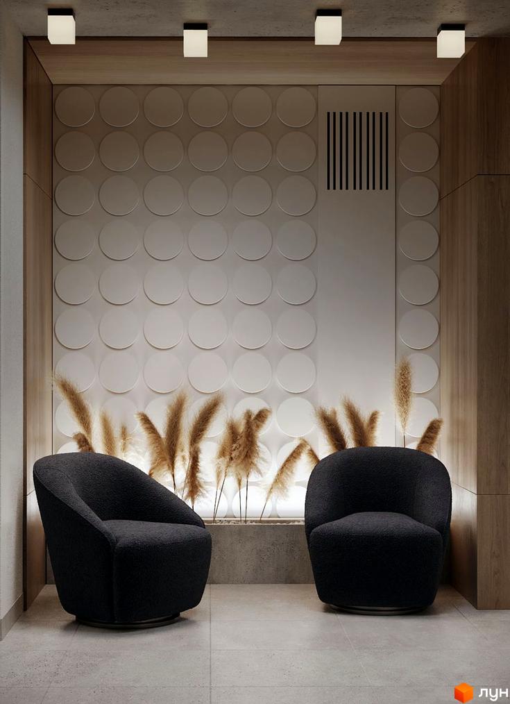 Інтер'єр холу в ЖК SVOЇ PARKHOUSE з двома кріслами, декоративними рослинами та стіною з круглими елементами.