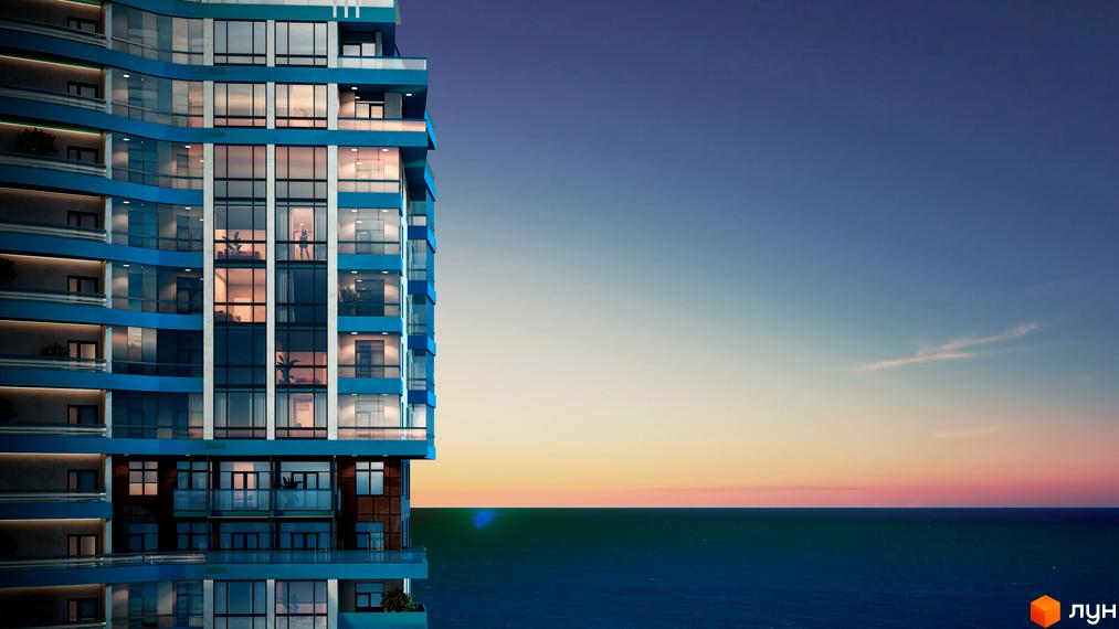 Житловий комплекс Aqua Marine біля моря. Висотна будівля з блакитним фасадом та панорамними вікнами.