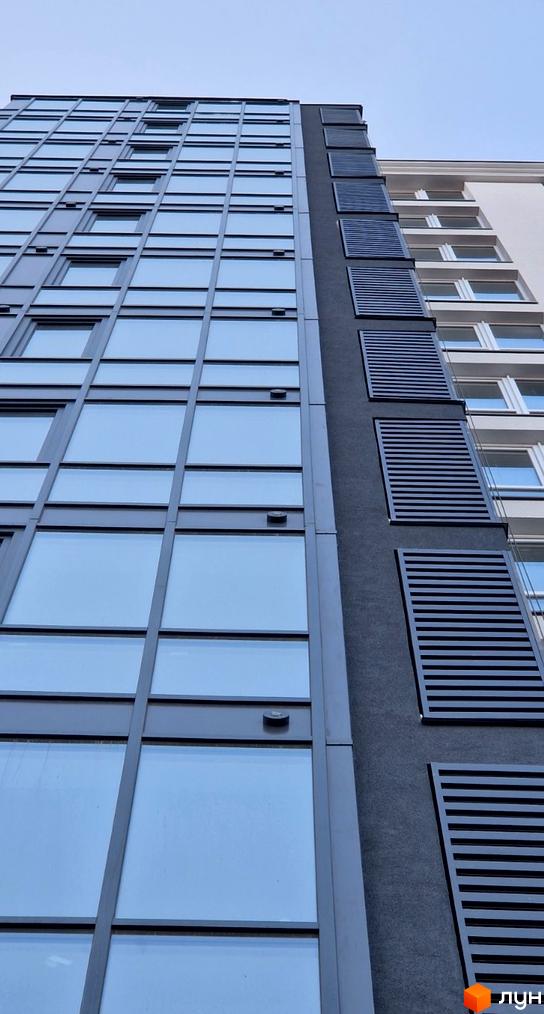 Фасад Житлового комплексу Янтарний з панорамними вікнами та темними сонцезахисними панелями.