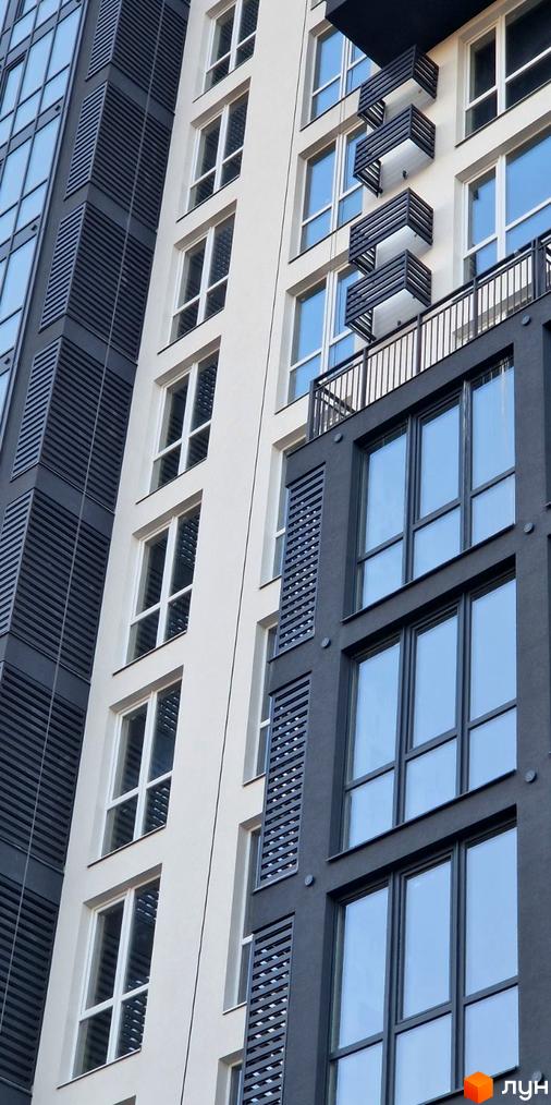 Фасад житлового комплексу Янтарний з великими вікнами та балконами. Сучасна архітектура новобудови.