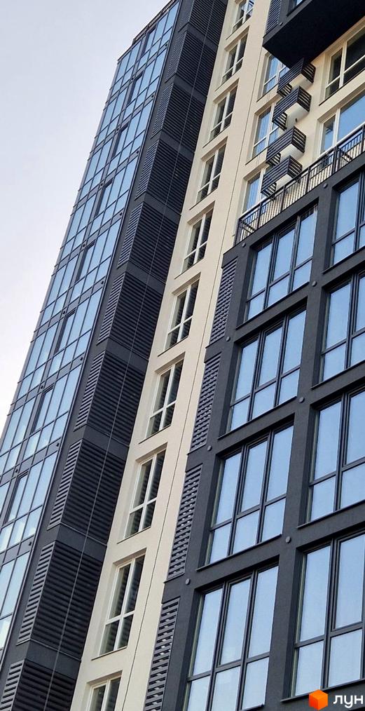 Зовнішній вигляд Житлового комплексу Янтарний з контрастними фасадами: темно-сірий з панорамними вікнами та світлий з вертикальними вікнами.