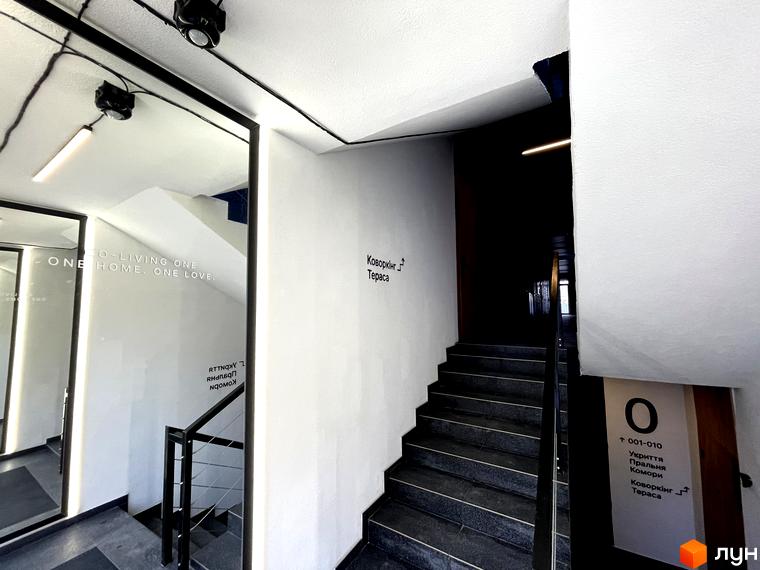Інтер'єр житлового комплексу Coliving EST з сходами та написами на стінах. Опис новобудови для SEO.