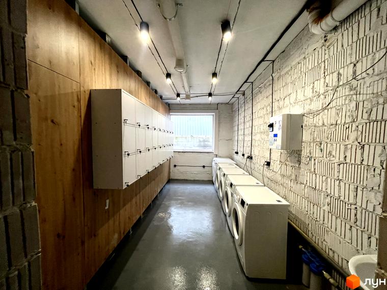 Пральна кімната в Coliving EST з пральними машинами та шафками для зберігання речей. Зручне та функціональне приміщення для мешканців.