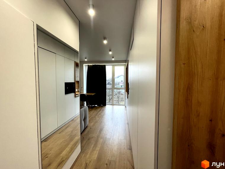 Інтер'єр квартири в Coliving EST з функціональною кухнею, дзеркалом у передпокої та видом на житлову забудову.