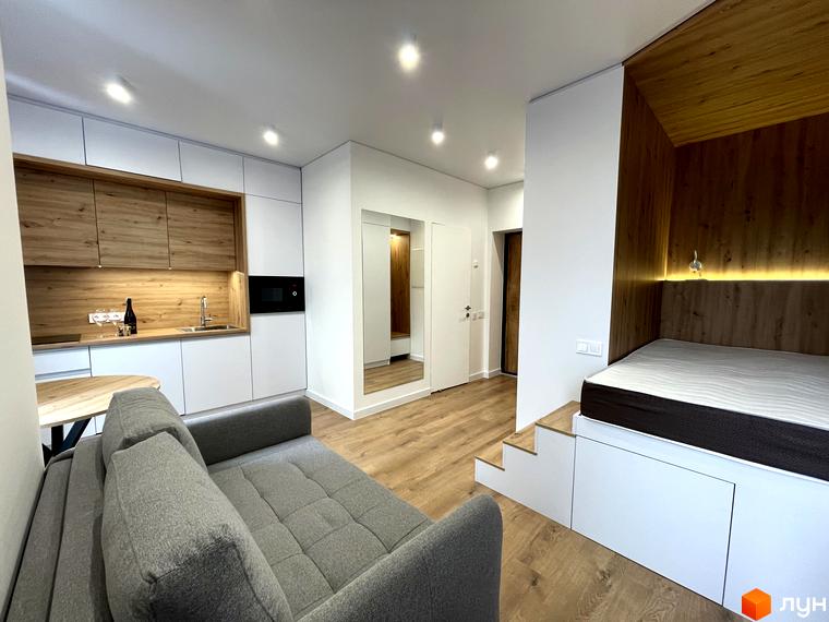 Інтер'єр квартири в Coliving EST з кухнею, вітальнею та спальною зоною. Компактний простір облаштований функціональними меблями та вбудованими рішеннями.