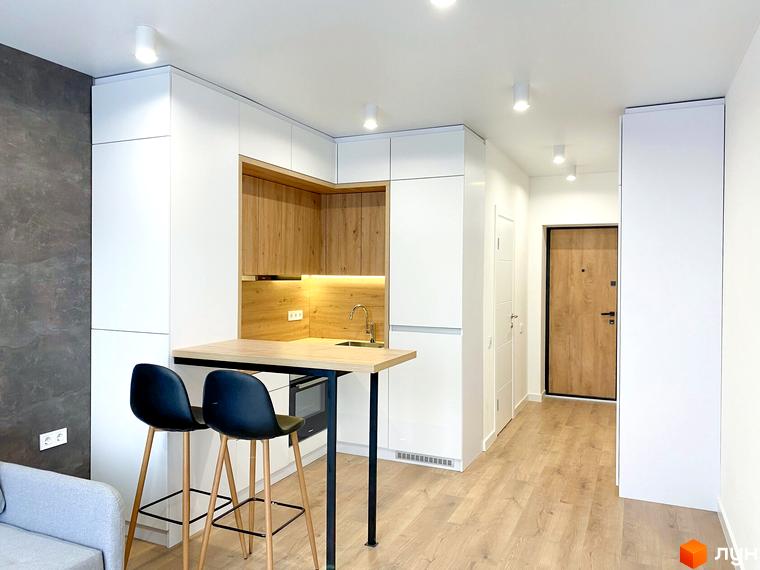 Інтер'єр студії в Coliving EST з барною стійкою та кухонною зоною. Сучасний дизайн та функціональне планування.