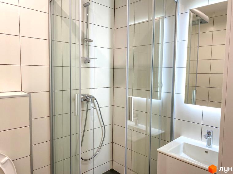 Сучасний санвузол у Coliving EST з душовою кабіною, раковиною та дзеркалом з підсвіткою. Опис інтер'єру ванної кімнати.