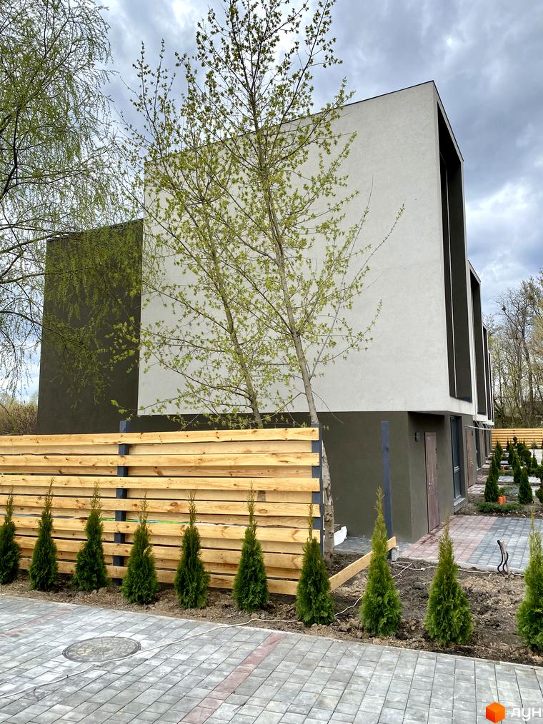 Зовнішній вигляд Elwood Townhouse з дерев'яним парканом та туями на прибудинковій території. Сучасна архітектура новобудови Elwood Townhouse.