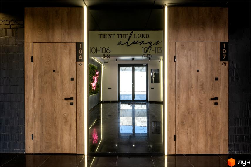 Coliving Akadem: двері з номерами 106 та 107 у коридорі з неоновим написом 