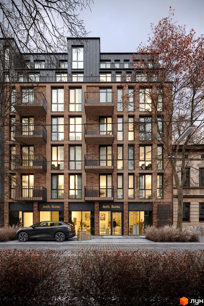 Житловий комплекс Avalon Yard з цегляним фасадом та великими вікнами. Перед будинком розташована брукована дорога та кущі.