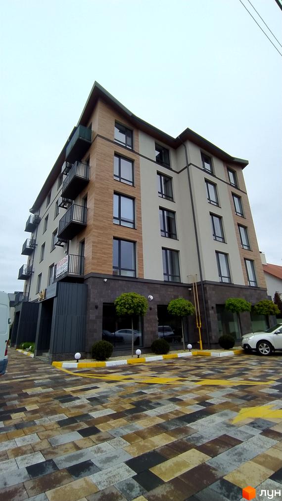 Зовнішній вигляд новобудови на пров. Урожайний, 16 з багатою прибудинковою територією. Будинок має сучасний вигляд з балконами та великими вікнами.