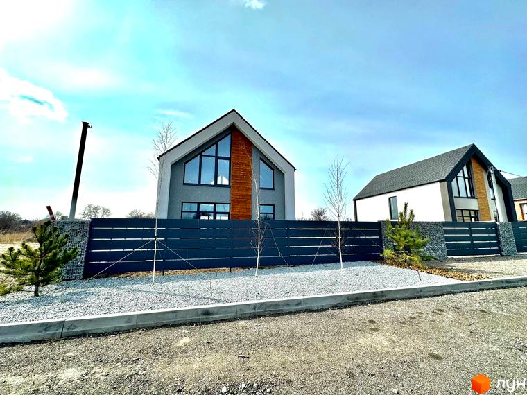 Котеджне містечко Fill House: двоповерхові будинки з великими вікнами та дерев'яними елементами, огороджені темним парканом та засипані гравієм.