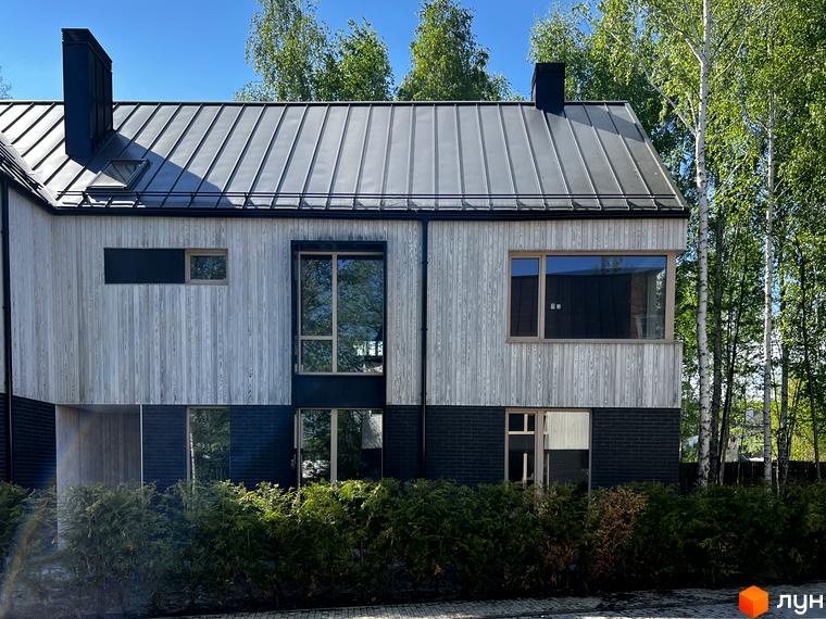 Котеджне містечко КМ Hidden House: фасад будинку з дерев'яною обшивкою та великими вікнами, зелений двір з деревами.