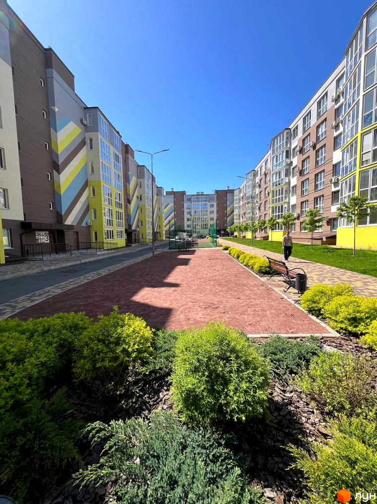 Зображення житлового комплексу Welcome Home на Стеценка. Багатоповерхові будинки з великими вікнами та яскравими фасадами. На території є доріжки, зелені насадження та лавки для відпочинку.