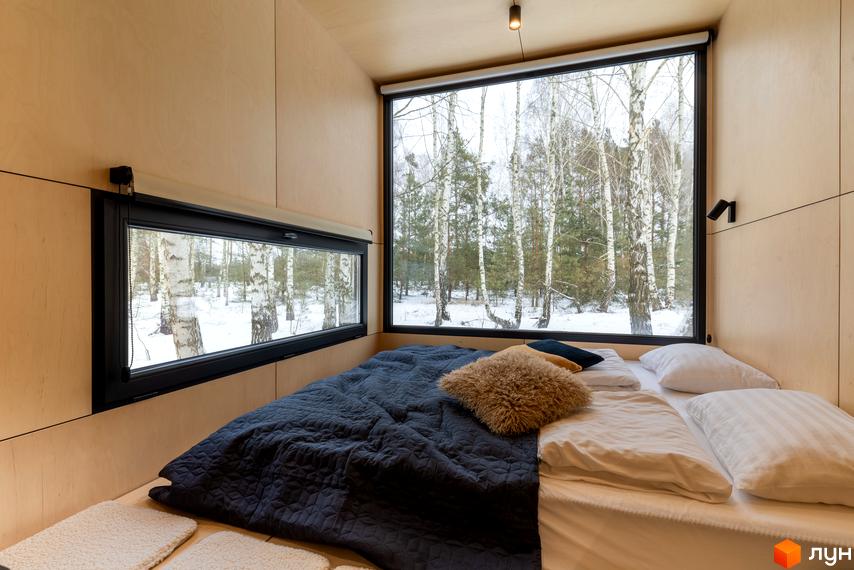 Затишна спальня в комплексі УЛІС з великим вікном, що виходить на зимовий ліс. Сучасний дизайн інтер'єру для комфортного проживання.