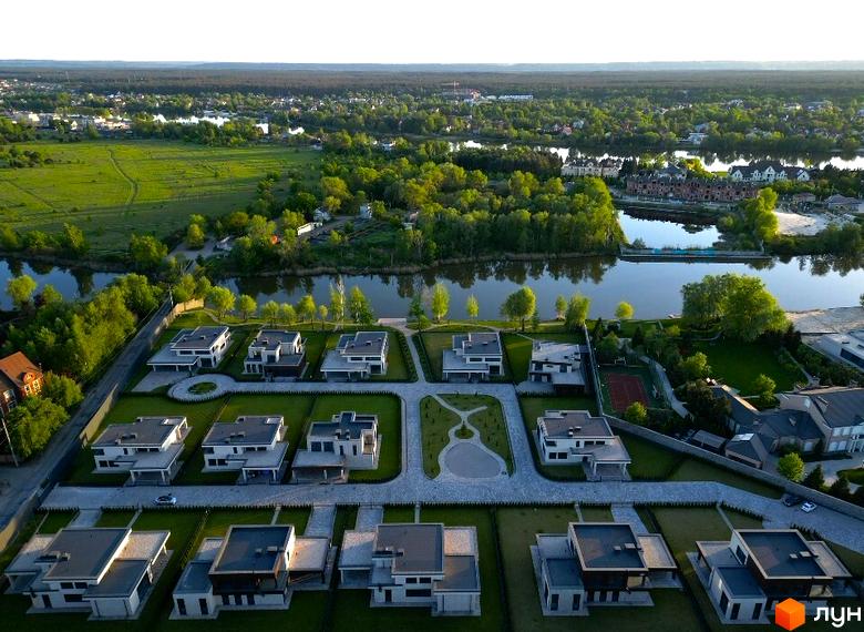 Котеджне містечко DAMBA RIVER PARK: сучасні будинки з пласкими дахами та просторі зелені ділянки з доглянутими газонами та доріжками.