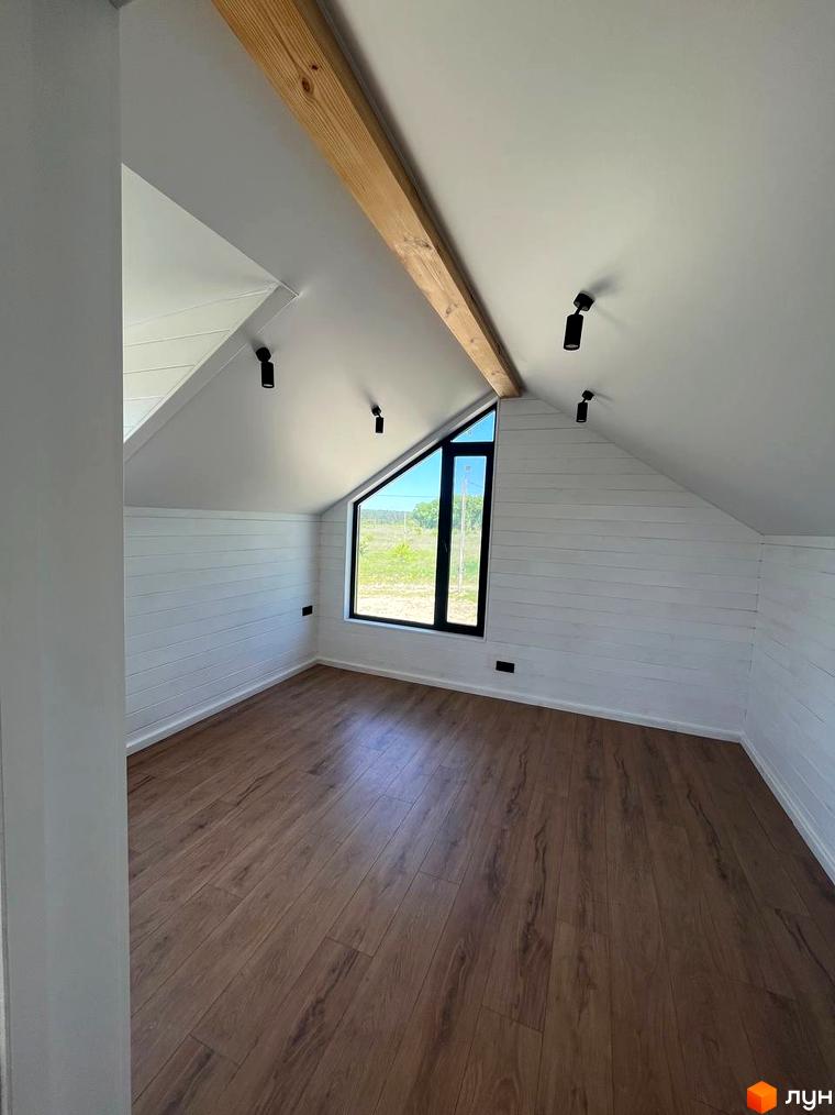 Котеджне містечко Залісся Village: простора кімната з дерев'яною підлогою та великим трикутним вікном, що виходить на зелену місцевість.