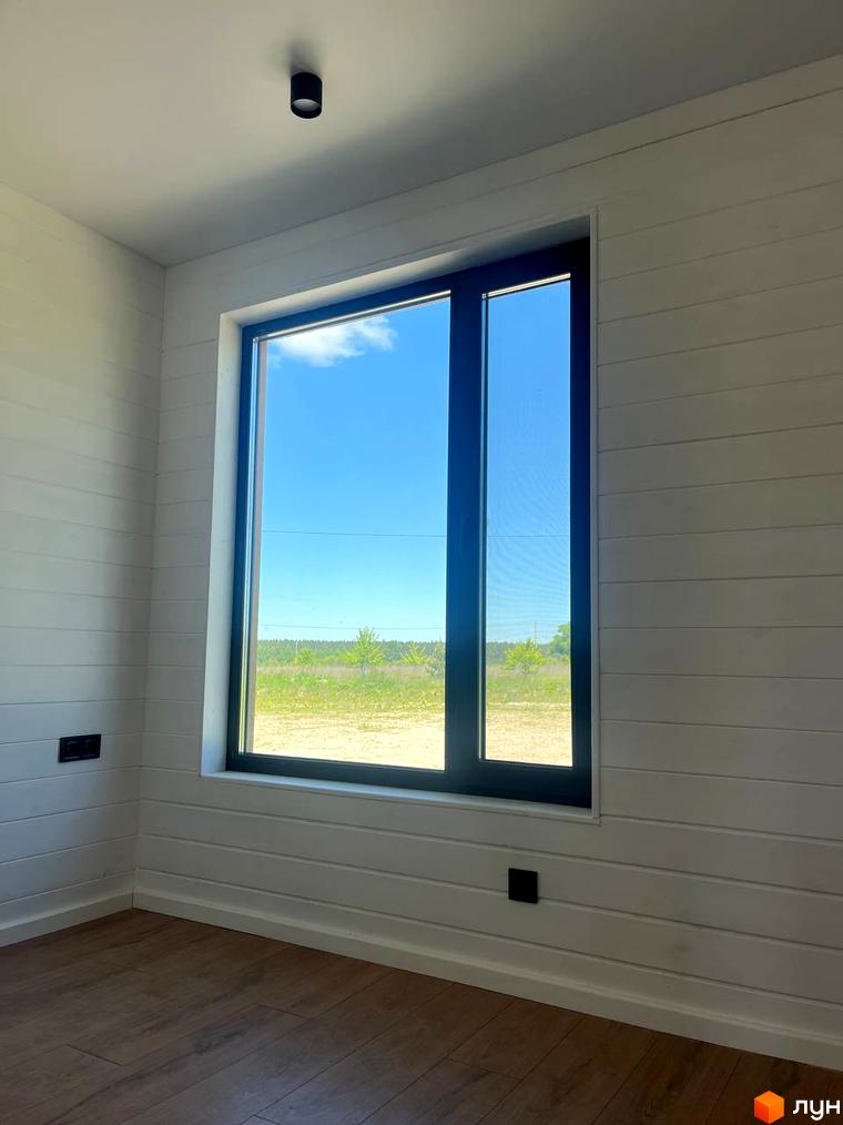 Котеджне містечко Залісся Village: білий будинок з великим вікном, вид на зелену галявину та блакитне небо. Ідеальне місце для життя.