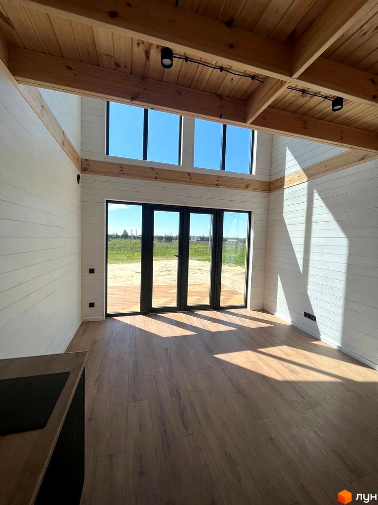 Котеджне містечко Залісся Village. Інтер'єр будинку з дерев'яною стелею, великими вікнами та виходом на терасу.