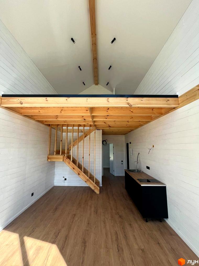 Котеджне містечко Залісся Village. Інтер'єр будинку з дерев'яними балками, сходами на другий поверх та кухнею.