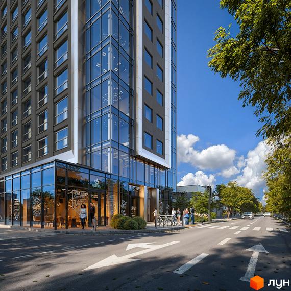 Зовнішній вигляд новобудови The Five Hotel з панорамними вікнами та фасадом з темних панелей. Поруч дорога з розміткою та зелені насадження.
