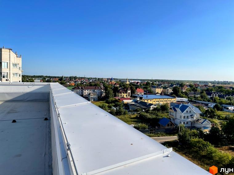 Вид з даху на житловий комплекс Петрівські Липки та прилеглі будівлі. На зображенні видно багатоповерховий будинок та приватні будинки з зеленими насадженнями.