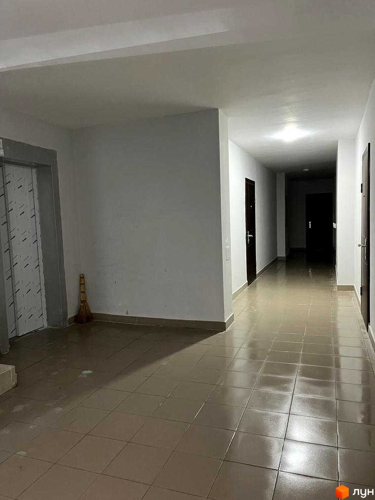 Загальний коридор Житлового комплексу на вул. Тараскова, 5: світлий простір з плитковою підлогою та ліфтом.