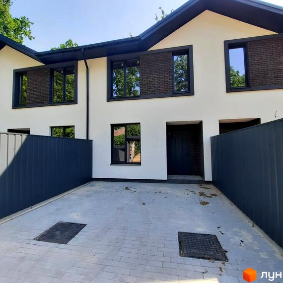 Таунхаус Т-37 – це двоповерховий будинок з цегляними вставками та темними вікнами, розташований на вимощеному подвір'ї з огорожею.