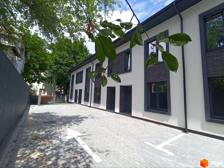 Будинок житлового комплексу на вул. Ярославська, 26в з парковкою та стрілкою напрямку руху.