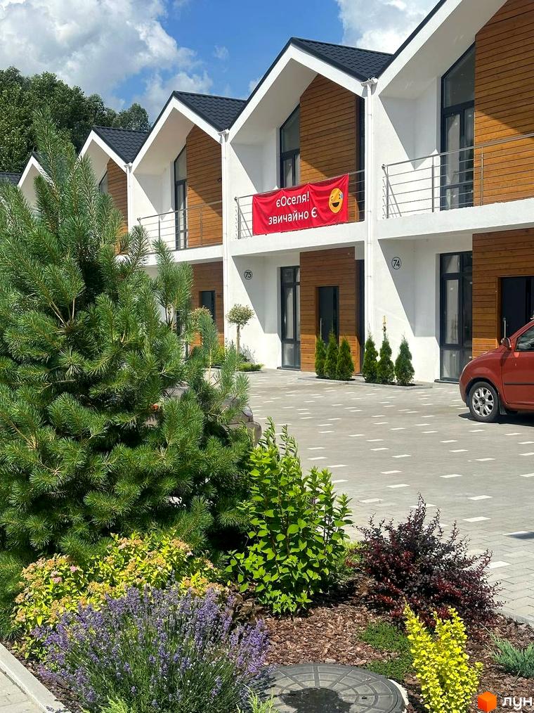 Зовнішній вигляд таунхаусів в Котеджному містечку Prydesennya Eco Village з доглянутою прибудинковою територією та ландшафтним дизайном.