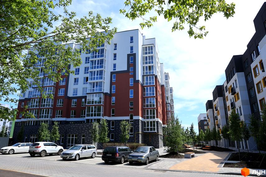 Житловий комплекс Олімп: багатоповерхові будинки з панорамними вікнами та балконами. Прибудинкова територія з парковкою та зеленими насадженнями.