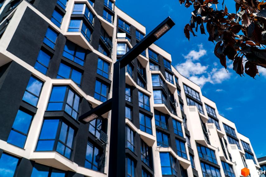 Зовнішній вигляд будинку в Житловому комплексі Паркова Алея. Багатоповерхова будівля з великими вікнами та освітленням.