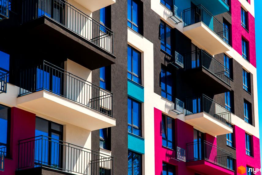 Зовнішній вигляд будинку Житлового комплексу Family Plaza з балконами та вікнами. Фасад пофарбований в різні кольори.