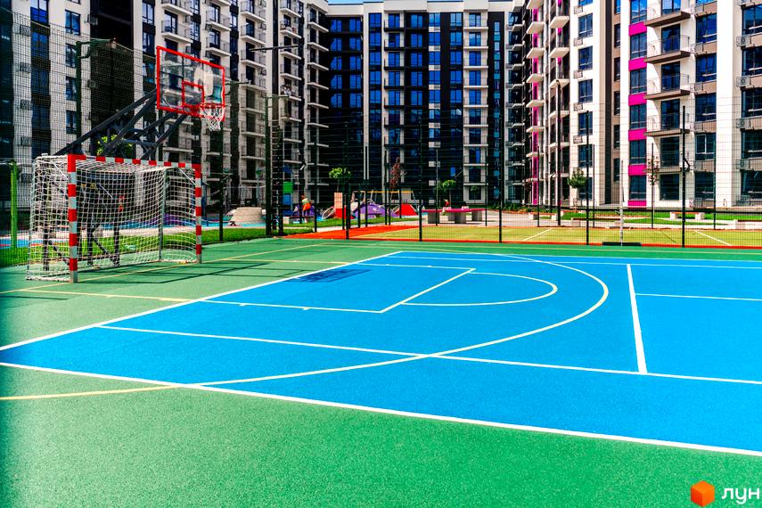 Зображення ігрового майданчика з баскетбольним кошиком та футбольними воротами у Житловому районі Family Plaza.