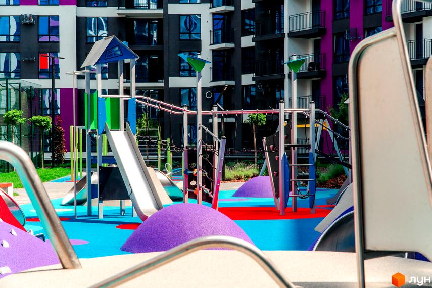 Зображення дитячого майданчика біля Житлового комплексу Family Plaza. На задньому плані видно багатоповерховий будинок.