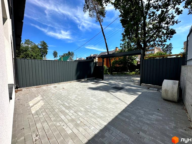 Фасад Таунхаусів Т-35 з білою стіною та темним дахом. В'їзд на територію вимощений сірою бруківкою з темним парканом.